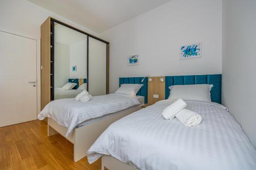 a bedroom with two beds and a mirror at Villa Veronika Apartments in Crikvenica