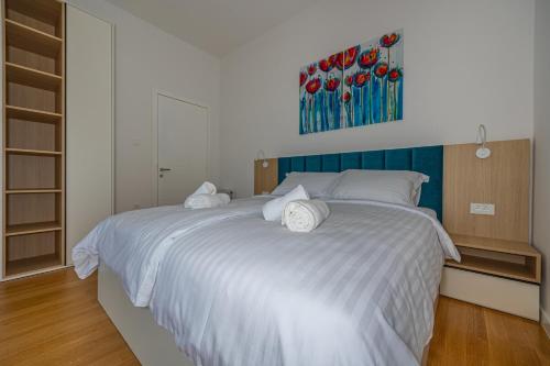 a bedroom with a large white bed with white pillows at Villa Veronika Apartments in Crikvenica