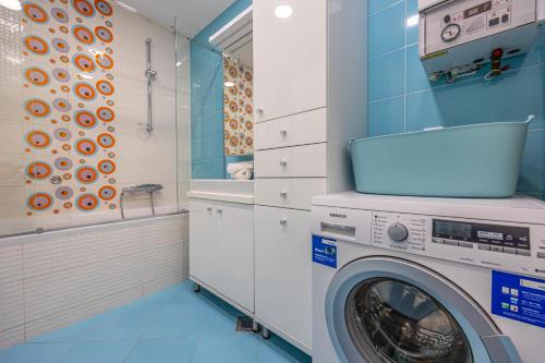 a washing machine in a bathroom with blue tiles at Villa Veronika Apartments in Crikvenica