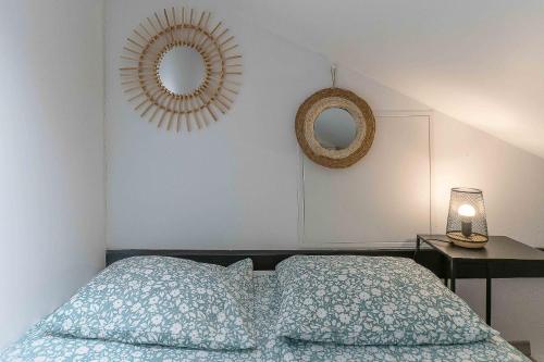 een slaapkamer met een bed, een spiegel en een lamp bij Résidence Le Celest - Appartements climatisés - Centre ville in Vichy