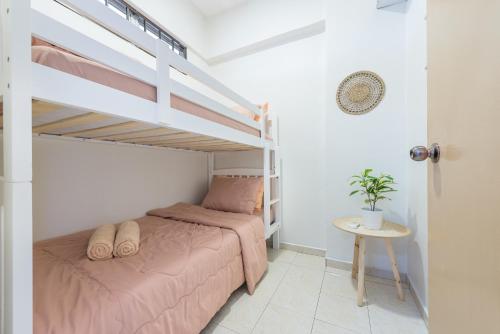 - une chambre avec un lit et des lits superposés dans l'établissement PortDickson Cozy Muji Home 10Pax3BR 1min to beach, à Port Dickson