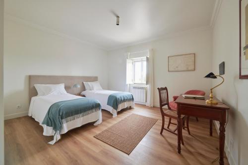 a bedroom with two beds and a desk and a desk at Luxury Farmhouse with Swimming Pool, By TimeCooler in Sobral de Monte Agraço