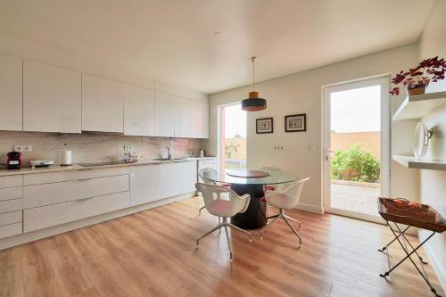 a kitchen with white cabinets and a table and chairs at Luxury Farmhouse with Swimming Pool, By TimeCooler in Sobral de Monte Agraço