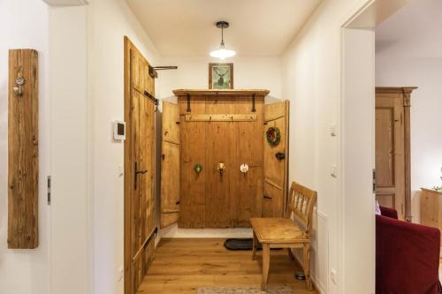 a hallway with a wooden door and a chair at Lina in Rottenbuch