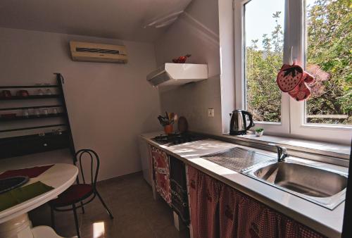 a kitchen with a sink and a window at Studio Bilka in Komiža