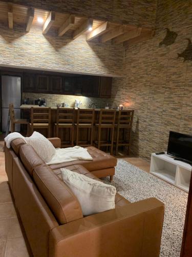 a living room with a brown couch and a kitchen at Vivenda do Cielo in Salga