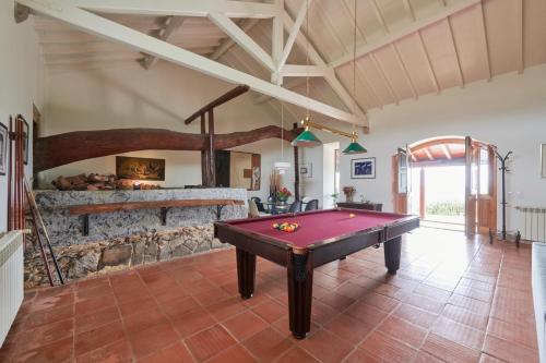 a pool table in a room with a stone fireplace at Luxury Farmhouse with Swimming Pool, By TimeCooler in Sobral de Monte Agraço