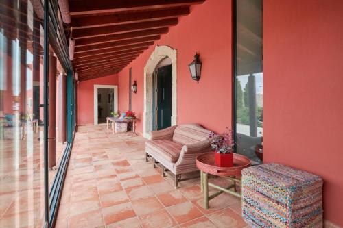 a living room with red walls and a couch and a table at Luxury Farmhouse with Swimming Pool, By TimeCooler in Sobral de Monte Agraço