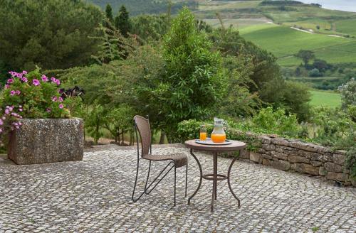 a table and two chairs sitting on a patio at Luxury Farmhouse with Swimming Pool, By TimeCooler in Sobral de Monte Agraço