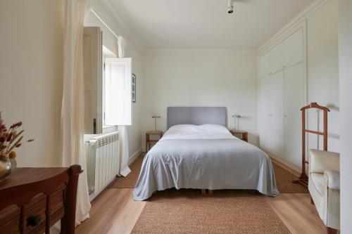 a bedroom with a large white bed and a window at Luxury Farmhouse with Swimming Pool, By TimeCooler in Sobral de Monte Agraço