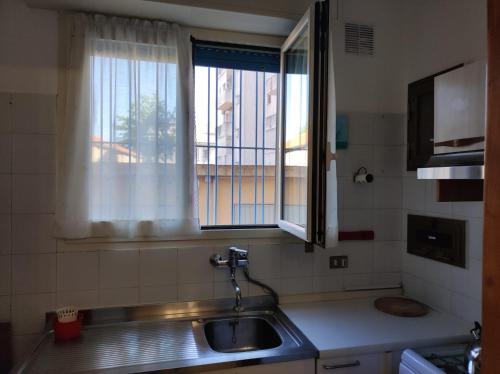 una cucina con lavandino e finestra di L'anfiteatro a Vercelli