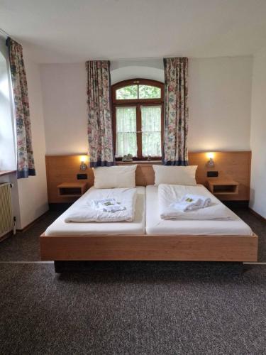 een slaapkamer met een groot bed en een raam bij Pension Benedikt in Aschau am Inn