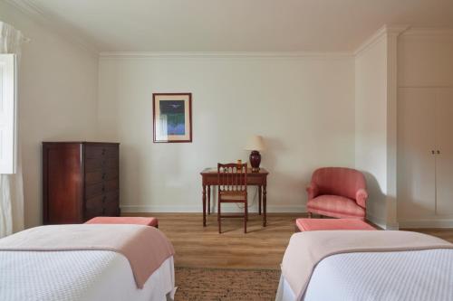 a bedroom with two beds and a chair and a desk at Luxury Farmhouse with Swimming Pool, By TimeCooler in Sobral de Monte Agraço
