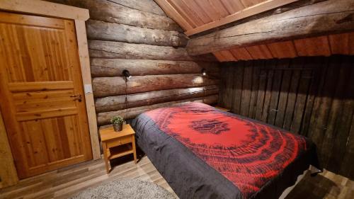 una camera con un letto in una baita di tronchi di Villa Kaunisvirta a Utbyn