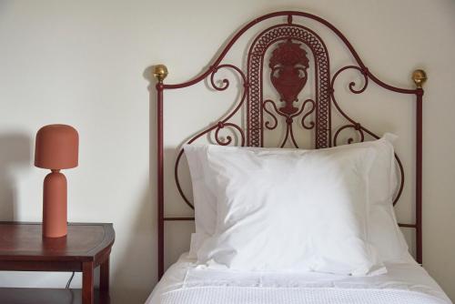 a bed with a white pillow next to a table at Luxury Farmhouse with Swimming Pool, By TimeCooler in Sobral de Monte Agraço