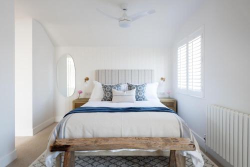 a white bedroom with a large bed and a window at Sanderling in Salcombe