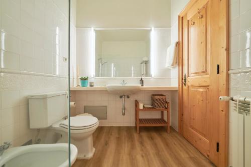 a bathroom with a toilet and a sink and a mirror at Luxury Farmhouse with Swimming Pool, By TimeCooler in Sobral de Monte Agraço