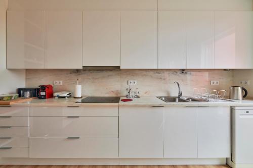 a white kitchen with white cabinets and a sink at Luxury Farmhouse with Swimming Pool, By TimeCooler in Sobral de Monte Agraço