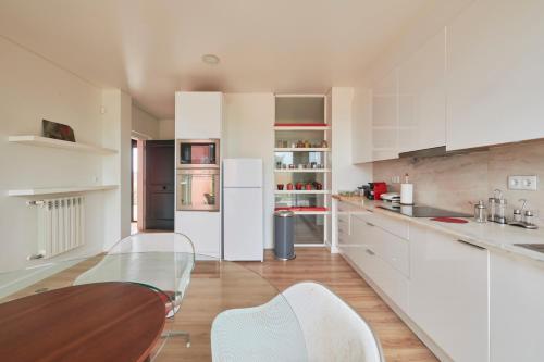 a kitchen with a glass table and white cabinets at Luxury Farmhouse with Swimming Pool, By TimeCooler in Sobral de Monte Agraço