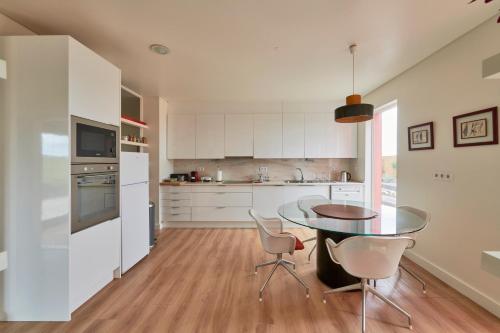 a kitchen with a table and chairs in a room at Luxury Farmhouse with Swimming Pool, By TimeCooler in Sobral de Monte Agraço