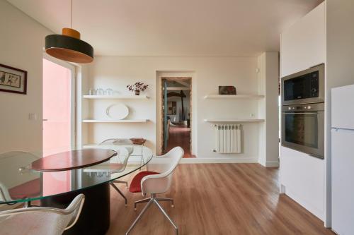 a kitchen and dining room with a glass table and chairs at Luxury Farmhouse with Swimming Pool, By TimeCooler in Sobral de Monte Agraço