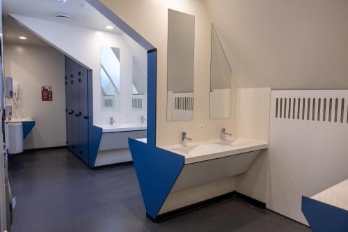 łazienka z 2 umywalkami i dużym lustrem w obiekcie Hostel Uppelink w Gandawie