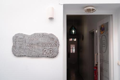 ein Schild an einer Wand neben einem Flur in der Unterkunft Aggelikoula Rooms in Tinos