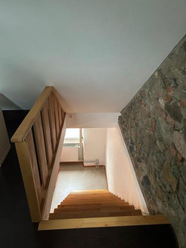 escalera en una habitación con pared de piedra en M-Hostel, en Lucerna
