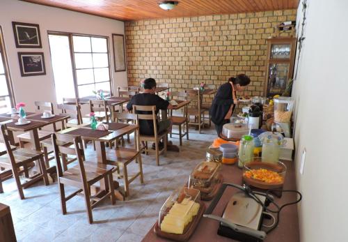 Due uomini seduti ai tavoli in un ristorante di Pousada Tarumim a Vale do Capao