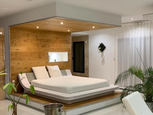 1 dormitorio con 1 cama grande y espejo en EMLAVIE Loft avec SPA privatif, en Chasseneuil-du-Poitou