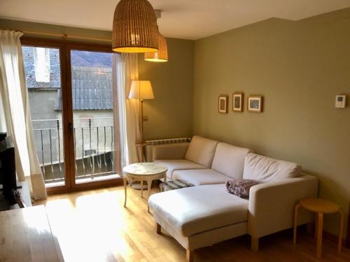 uma sala de estar com um sofá e uma grande janela em Casa Lauré II - PANTICOSA em Panticosa