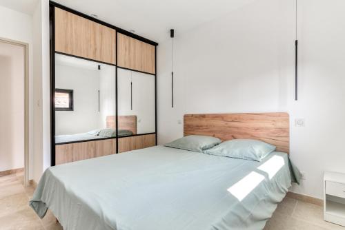 um quarto com uma cama grande e uma cabeceira em madeira em L'appenti em Luc-sur-Orbieu