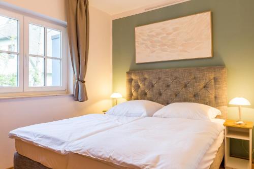 una camera da letto con un grande letto bianco con due lampade di Strandleben 06 - Lyonel Feininger a Ahrenshoop