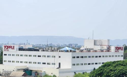 Un edificio blanco con un cartel conservador. en 7 Apple Hotel Aurangabad, en Aurangabad