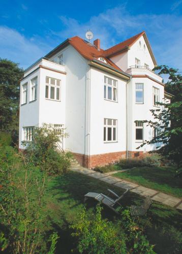 ein großes weißes Haus mit rotem Dach in der Unterkunft Villa Daheim - FeWo 03 in Ostseebad Kölpinsee