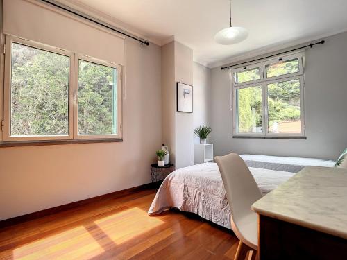 Un dormitorio con una cama y dos ventanas. en Amarelo Apartment by Atlantic Holiday, en São Vicente