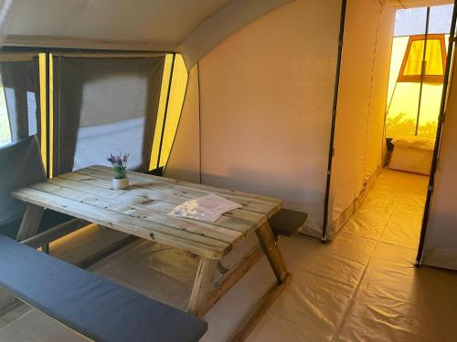 a wooden table and a chair in a tent at Ingerichte De Waard tent - 5 personen in Beilen
