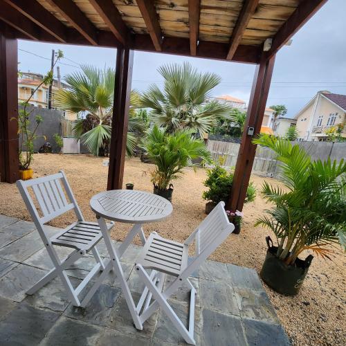 een witte tafel en 2 stoelen op een patio bij Le Chaleureux in La Gaulette