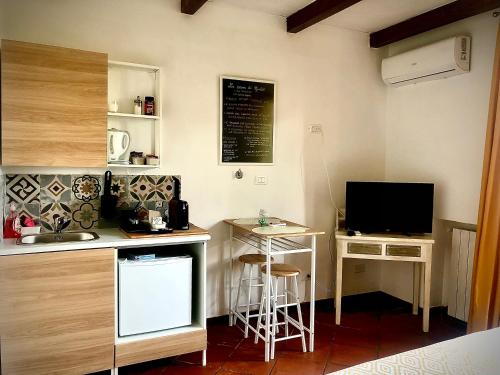 a kitchen with a counter and a desk with a tv at La casa di Giulio in Maccarese