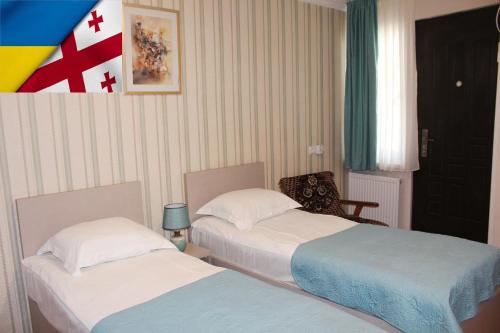 a room with two beds and a flag on the wall at Guest House Old Tiflis 5 in Tbilisi City