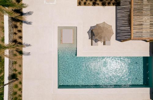 - une vue aérienne sur une piscine avec un parasol dans l'établissement Cocopalm Villas Naxos, à Naxos Chora