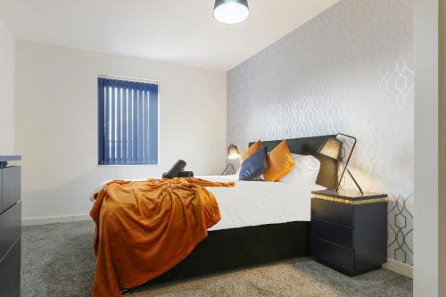 Home Away From Home - Contractors & Leisure في شيفيلد: غرفة نوم مع سرير مع بطانية برتقالية عليه