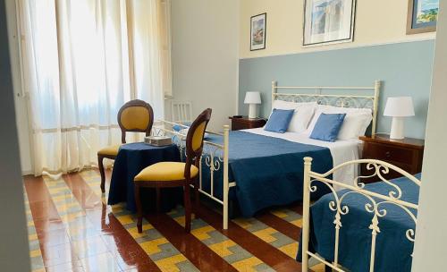 um quarto com uma cama, uma mesa e cadeiras em Casa Verga em Siracusa