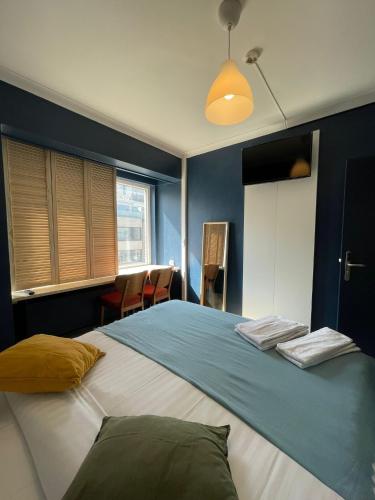 a bedroom with a large bed with blue walls at Hotel HEB in Ostend