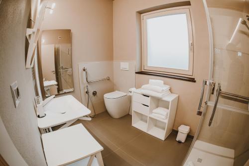 a bathroom with a toilet sink and a window at LA CASCINA DI CARLOTTA 1846 agriturismo in Alba