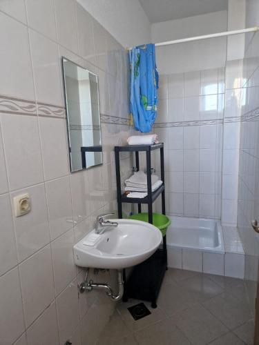 a bathroom with a sink and a bath tub at Apartmani Biskup in Dugi Rat