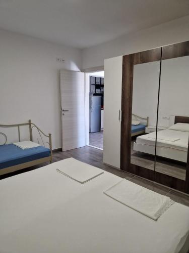 a bedroom with two beds and a mirror at Apartmani Biskup in Dugi Rat