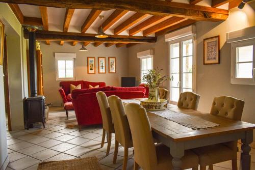 a living room with a table and a red couch at Gite Un Le Terrail in Villard