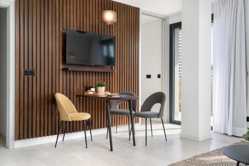 a room with a table and chairs and a tv on a wall at TSA La Rambla in Barcelona