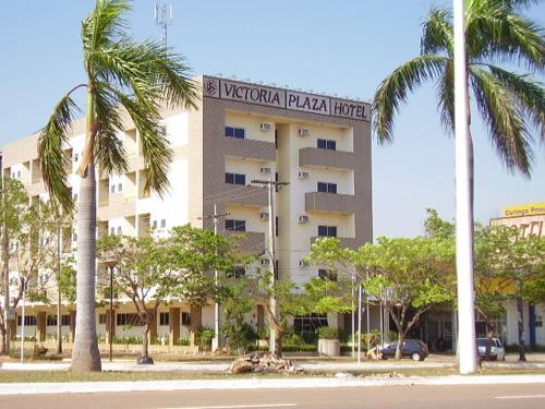 un hotel con palmeras frente a un edificio en Victoria Plaza Hotel, en Palmas